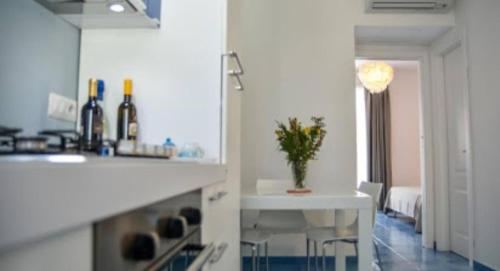 eine Küche mit einer weißen Theke und einem Tisch mit einer Pflanze in der Unterkunft A casa di Silvia in Scario