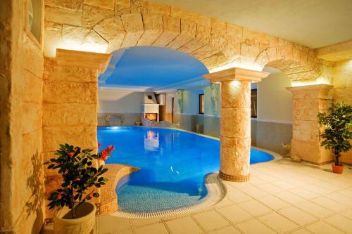 a large swimming pool in a building with an arch at Pałac Margot Nature&SPA in Karpacz