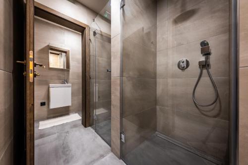a bathroom with a shower with a glass door at Horská Chata Ostružiny in Donovaly