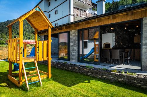 a wooden play structure in the yard of a house at Horská Chata Ostružiny in Donovaly