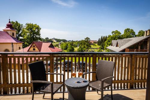 a patio with three chairs and a table on a balcony at Horská Chata Ostružiny in Donovaly