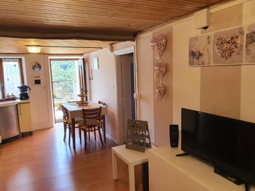 a living room with a flat screen tv and a table at Coccinella House in Calasca Castiglione