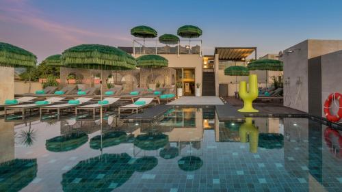 una piscina en un complejo con sillas y sombrillas en El Llorenc Parc de la Mar - Adults Only (+16) en Palma de Mallorca