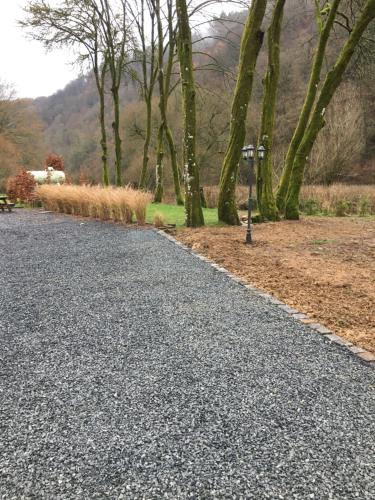 an empty road with trees and a parking meter at Chez Arsène in Bouillon