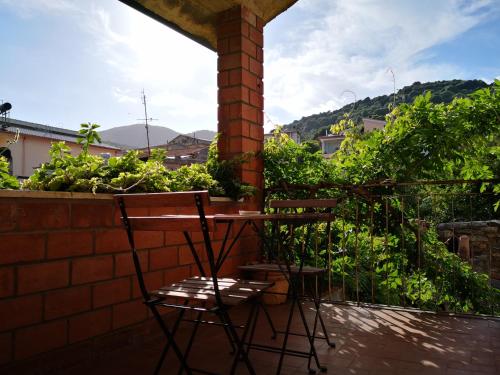 a table and two chairs on a balcony with plants at Zia Chiarina in San Nicolò Gerrei