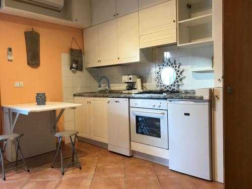 a kitchen with white appliances and a small table at Il Nido del Gabbiano - Riviera Adriatica in Martinsicuro