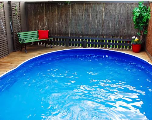 a large plunge pool in a backyard with a bench at Almond Court Motel in Alexandra