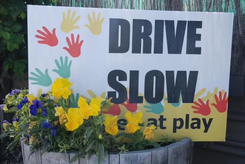 a sign that says drive slow at play in a flower pot at Almond Court Motel in Alexandra