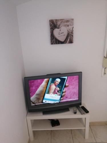 a flat screen tv sitting on a table in a room at studio refait a neuf avec la fibre in Vaugneray