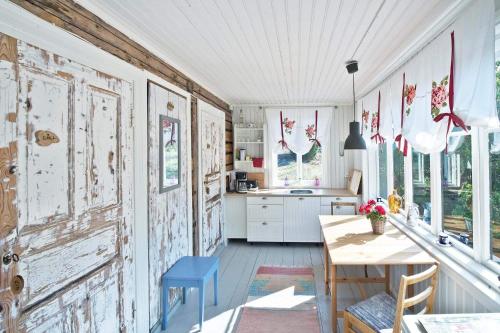 una cocina con una puerta antigua, una mesa y sillas en Hannaksen tila, en Korpo