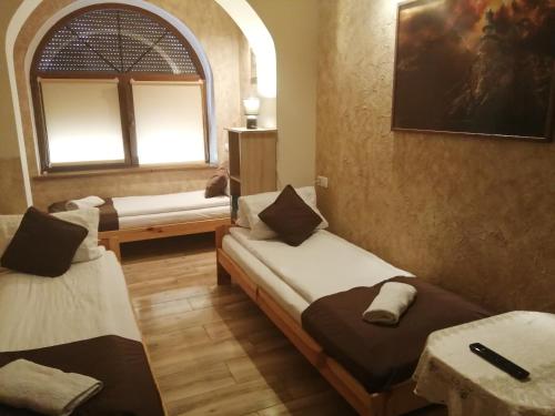 a room with two beds and a window at Apartament i pokoje gościnne Gniezno in Gniezno