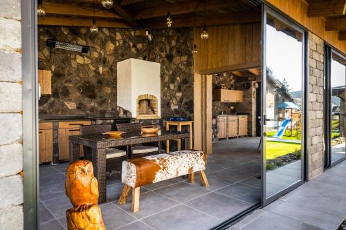 an open kitchen with a dining table and glass doors at Horská Chata Ostružiny in Donovaly