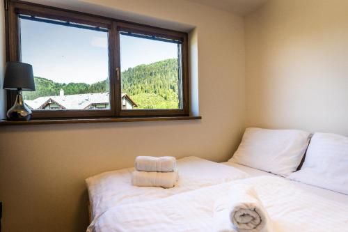 a bedroom with a white bed and a window at Horská Chata Ostružiny in Donovaly