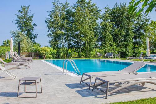 a swimming pool with a bunch of chairs and a table at Orchidea Del Garda in Peschiera del Garda