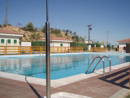 a swimming pool with blue water and wooden fences at Alojamiento Cerro Socorro in Cuenca