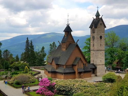 a large building with a clock tower in a garden at Kolorowe Karkonosze in Przesieka