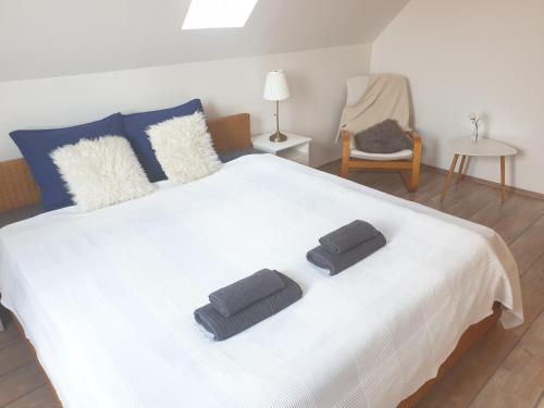 1 dormitorio con 1 cama blanca grande y 2 almohadas en B6 Apartman, en Veszprém