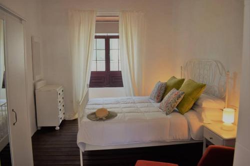 un dormitorio con una cama blanca con sombrero en La Casa Vieja, en Arafo