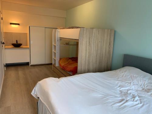 een slaapkamer met een stapelbed en een keuken bij Parel aan het strand in Oostende