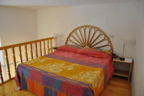 リーパリにあるAppartamenti Oretoのベッドルーム1室(木製ヘッドボード付きのベッド1台付)