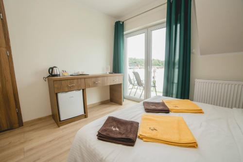 een slaapkamer met een bed met twee handdoeken erop bij Willa Mirella in Dębki