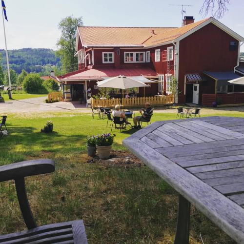 a picnic table in front of a red barn at Sjugare Gård Bed & Breakfast in Leksand