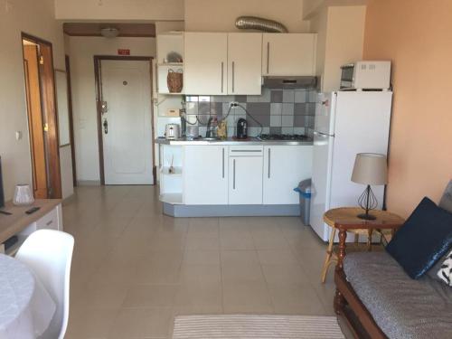 a kitchen with white cabinets and a white refrigerator at Over the Rainbow in Almada