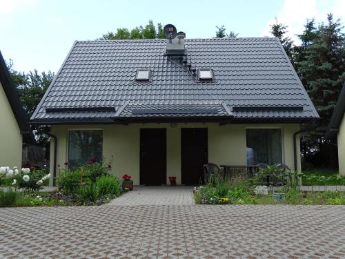a house with a black roof and a driveway at Cicha Przystań in Nowy Dwór Gdański