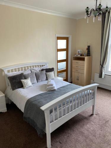 a bedroom with a white bed and a dresser at The Victoria in Saltburn-by-the-Sea