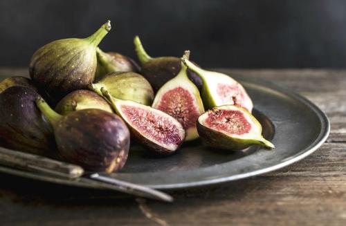 a plate of cut up figs on a wooden table at Villa Mimoza Blagaj in Blagaj