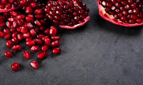 a pomegranate cut in half next to a pile of fruit at Villa Mimoza Blagaj in Blagaj