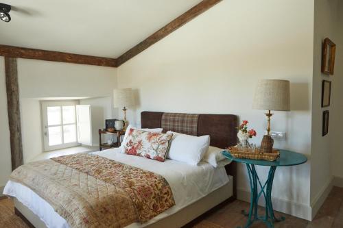 een slaapkamer met een bed en een tafel bij Hotel Caserio Aldeallana in Segovia