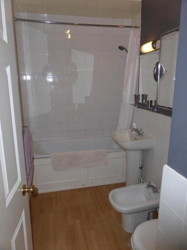 a bathroom with a tub and a sink and a toilet at Central Georgian Garden Flat with Free Parking in Bath