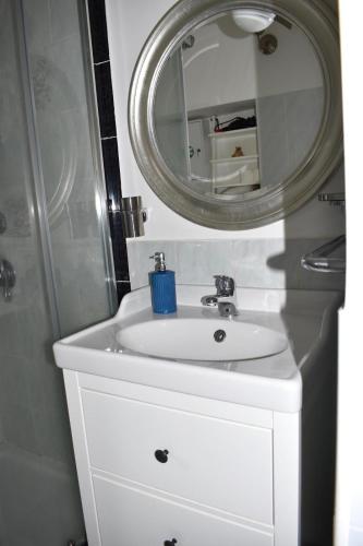 a bathroom with a white sink and a mirror at Suali Case nel Borgo in Civita Castellana