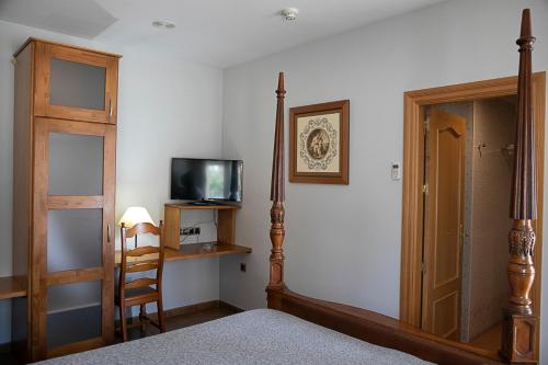 a bedroom with a bed and a tv and a chair at Hotel Restaurante Setos in Motilla del Palancar