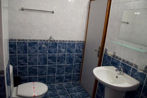 bagno piastrellato blu con lavandino e servizi igienici di Bisser Obzor a Obzor