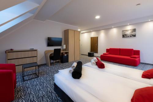 a hotel room with a bed and a red couch at Hotel Bardo in Bardo