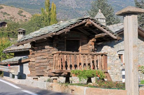 a log cabin with a wooden porch on the side of a road at Hotel Milleluci in Aosta