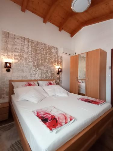 a bedroom with a white bed with red roses on it at Apartments 2 Ivanković in Stari Grad