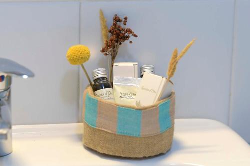 a basket with essential oils and flowers on a counter at Bio&B Acquaviva in Otranto