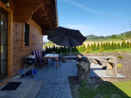 a patio with a table and an umbrella at Chata Hrozenka WELLNESS in Nový Hrozenkov