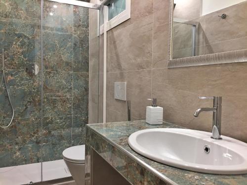 a bathroom with a sink and a toilet and a shower at Panoramic Apartment Poggettone Air conditioned in Punta Ala