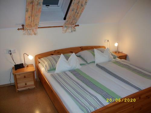 a bedroom with a large wooden bed with pillows at Ferienwohnung Moni in Geiseldorf