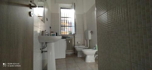 La salle de bains est pourvue d'un lavabo, de toilettes et d'une fenêtre. dans l'établissement LA SISTEMAZIONE BRILLANTINO PLATINUM, à Rozzano