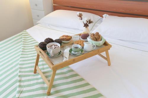 a tray of donuts and cups of coffee on a bed at Bio&B Acquaviva in Otranto