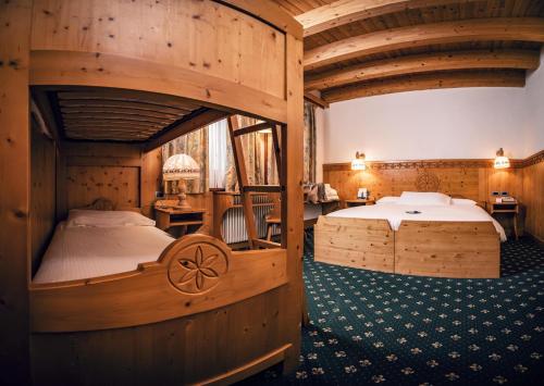 a bedroom with two beds in a room with wooden walls at Hotel San Giacomo Spa&Gourmet in Brentonico