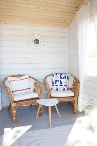 two wicker chairs and a table on a porch at Wästinn in Vöyri