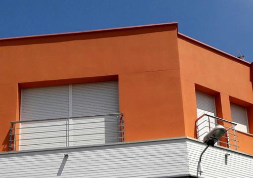 Edificio naranja con 2 ventanas y luz de la calle en MENORCA, en Malgrat de Mar