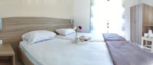a large white bed with a bowl of flowers on it at Ever Green in Kavos