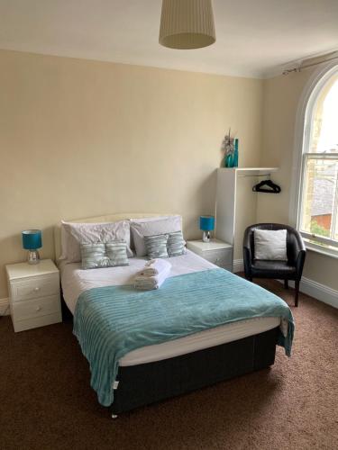 a bedroom with a large bed and a chair at The Victoria in Saltburn-by-the-Sea